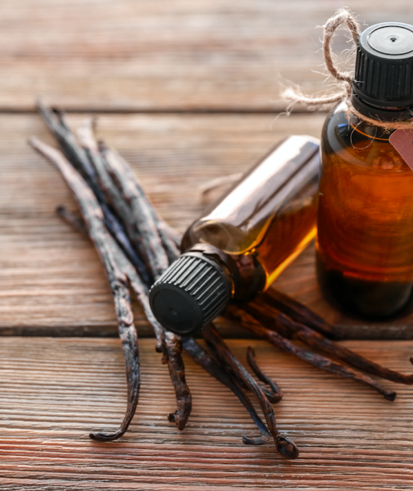 Vanilla pods and apothecary bottles inspiring the Vanilla Scented Candle